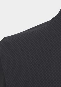 Schwarzes Sportbekleidungsgewebe mit strukturiertem Diamantmuster. Verfügt über glattes Material und kontrastierende Seitenpaneele für zusätzliche Details.