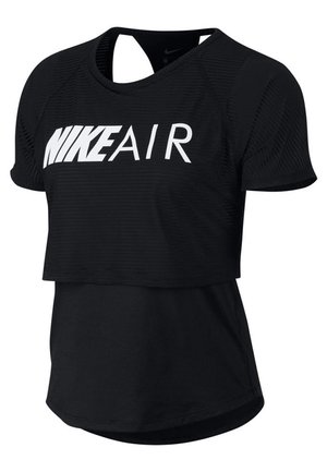 Sort kortærmet Nike Air cropped top lagdelt over en længere tætsiddende sort skjorte med rund halsudskæring.