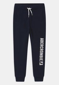 Navy sweatpants made of soft fabric with elastic waistband, white drawstring, side pockets, and "ABERCROMBIE" text along the left leg.