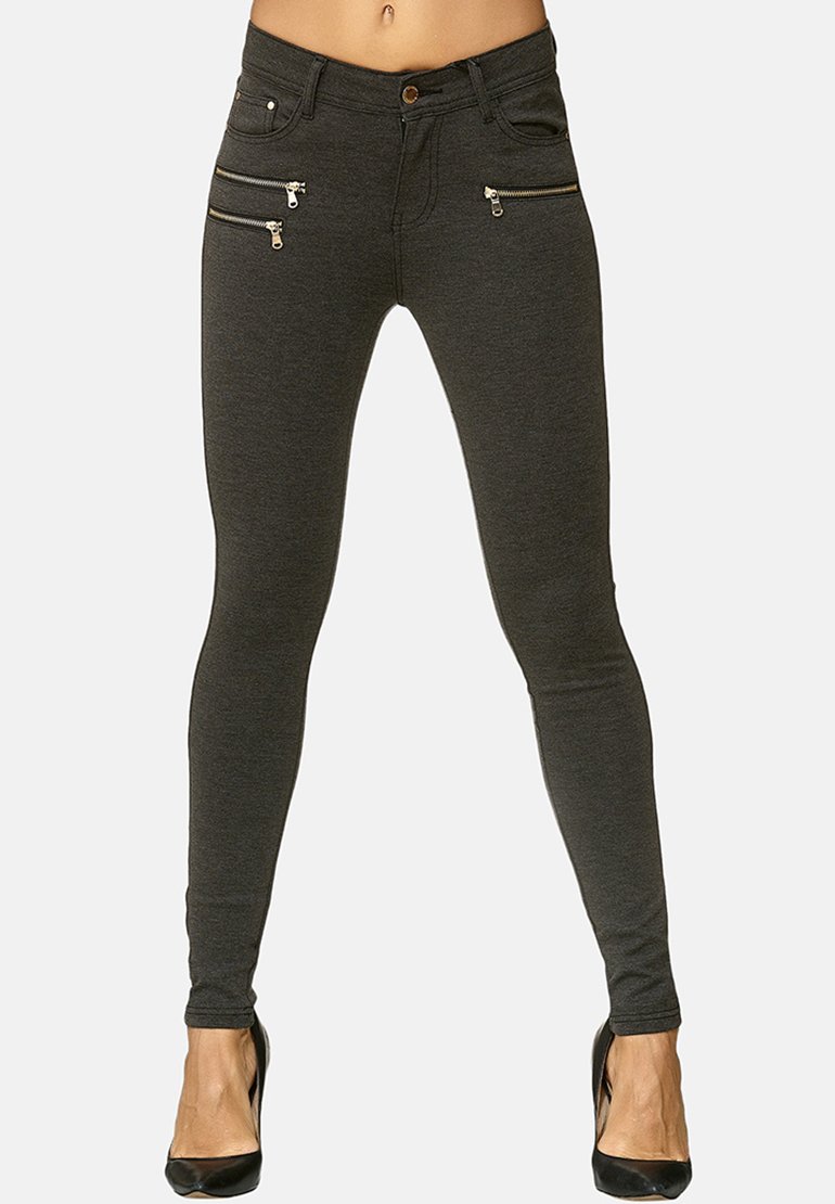 Grå skinny jeans med dragkedjeförsedda framfickor, en knapplåsning och en slät, elastisk textur. Kombination med svarta klackar.