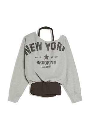 Siva majica dugih rukava s crnim naramenicama, tekstom "NEW YORK BROOKLYN U.S. TOUR" i grafikom zvijezde, detalj elastičnog crnog pojasa.