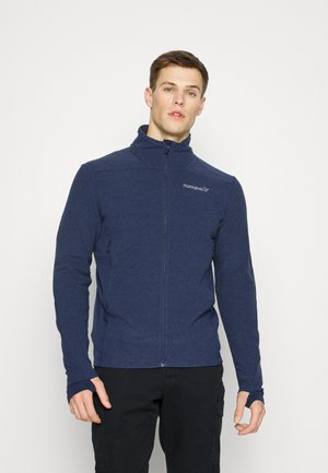 Veste en polaire bleu marine avec un col haut, une fermeture éclair sur toute la longueur et des poignets avec trou pour le pouce. Présente un branding discret sur la poitrine.