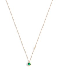 Guldhalsband med en rund grön ädelsten i en dekorativ bihang. Kedjan är fin och länkad.