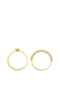 Set di anelli in oro, composto da una fascia circolare liscia e una decorata con piccole dettagli in rilievo lungo il bordo superiore.