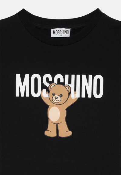 Camiseta de algodón negra con un gran gráfico de un oso con los brazos extendidos y la palabra "MOSCHINO" en letras blancas en negrita encima.