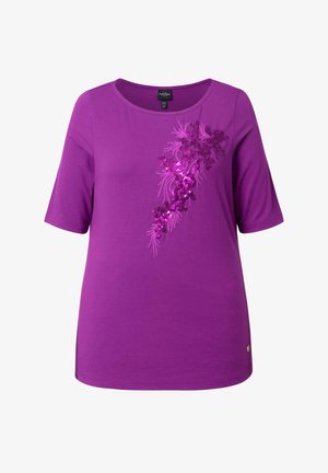 Lila Kurzarmshirt mit Rundhalsausschnitt und diagonaler, floraler Paillettenstickerei auf der rechten Vorderseite.