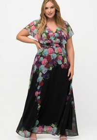 Robe maxi à imprimé floral aux diverses couleurs sur fond noir. Dotée d'un décolleté en V, de manches courtes à volants et d'une silhouette fluide.
