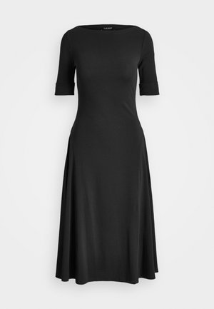 Crna haljina s kratkim rukavima, okruglim izrezom i lepršavom suknjom. Izrađena od mekog, rastezljivog materijala s detaljima sa strane.