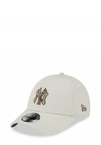 Gorra de béisbol beige con un logotipo bordado "NY" en marrón, visera curvada y un tejido texturizado con ojales de ventilación en los laterales.
