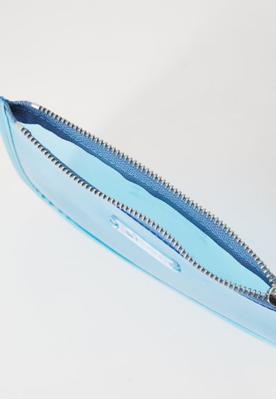 Borsa trasparente blu con chiusura a zip, caratterizzata da un esterno in plastica liscia e un rivestimento interno in tessuto di contrasto.