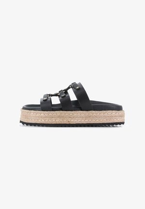 Sandalias de plataforma de cuero negro con tres correas anchas, suela intermedia de yute trenzado y suela exterior de goma texturizada. Los acentos incluyen herrajes en tono dorado.