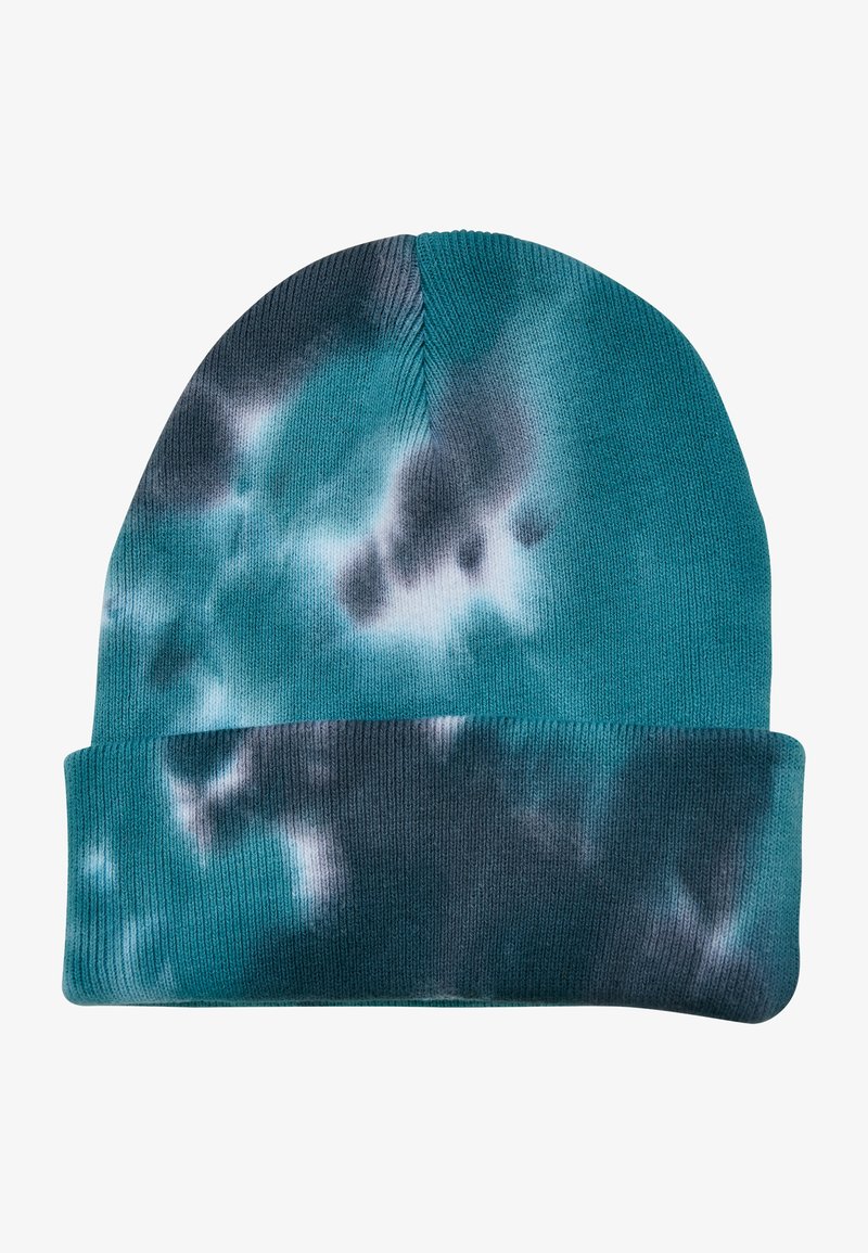 Pletena kapa v teal barvi z vzorcem tie-dye, ki vsebuje temno modre in sivo odtenke. Mehak material in zasnova s prepogibom.