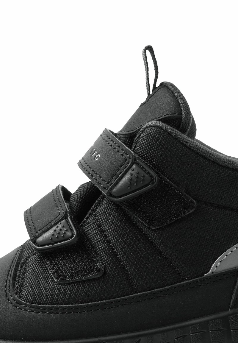 Czarne buty sportowe z teksturowanej tkaniny, z dwiema rzepami i wzmocnioną gumową podeszwą oraz pętelką przy pięcie.