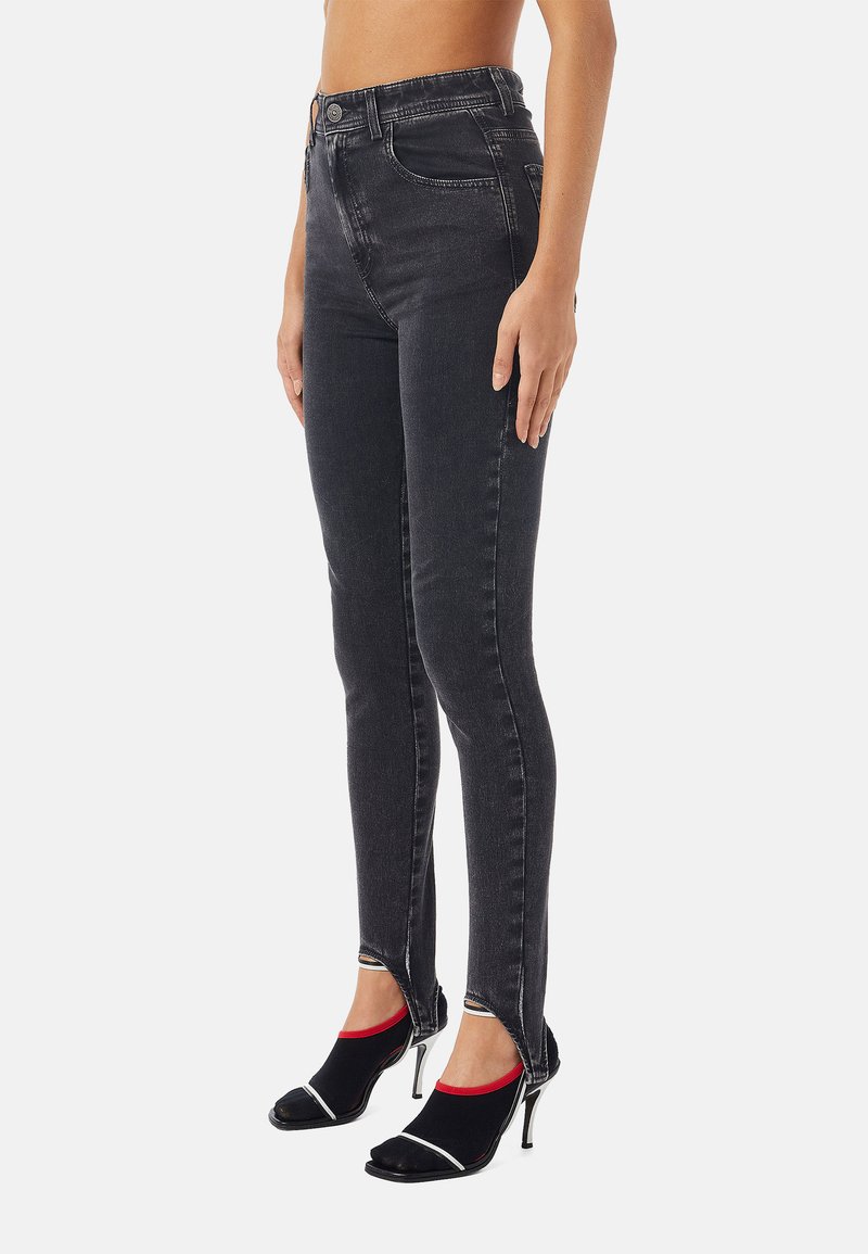 Jeans skinny neri a vita alta con una vestibilità elegante, caratterizzati da un orlo grezzo e cuciture dettagliate, abbinati a tacchi neri open-toe e calze colorate.