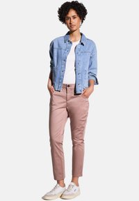 Vaateviitta vaaleansinisestä denimistä kahdella etutaskulla, valkoinen t-paita ja vaaleanpunaiset housut. Kermanväriset lenkkarit viimeistelevät asukokonaisuuden.