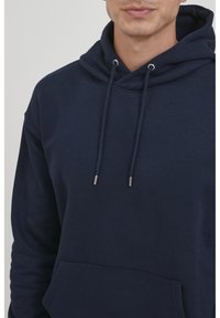Dunkelblaues Hoodie aus weichem Baumwollmaterial, mit einer Fronttasche, verstellbarem Kapuzenzug mit silbernen Enden und einem lässigen Schnitt.