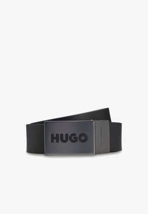 Ceinture en cuir noir avec une boucle en métal noir rectangulaire embossée du mot "HUGO" en lettres majuscules.