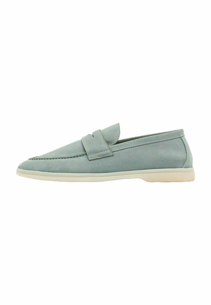 Lys blå ruskinds slip-on sko med spidse tæer, blød tekstur, minimal syning og en kontrasterende beige sål.