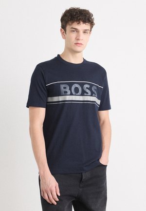 Námorně modré bavlněné tričko s odvážným šedým logem "BOSS" napříč hrudí, krátké rukávy a kulatý výstřih.