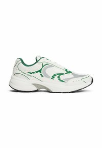 Sneaker atletiche bianche con accenti verdi, pannelli in rete e un motivo testurizzato. Presentano una suola imbottita e chiusura con lacci.