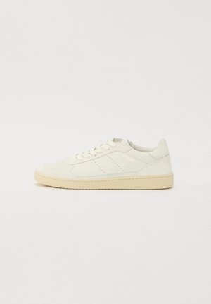 Weiße Ledersneaker mit texturiertem Finish, beiger Sohle, perforierten Details an der Zehe und dezentem Branding an der Seite.
