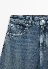 Džínové kalhoty tmavě modré barvy s klasickým pětipocket designem, se zapínáním na zip, knoflíkovým uzávěrem a jemnou texturou s efektivním odřením.