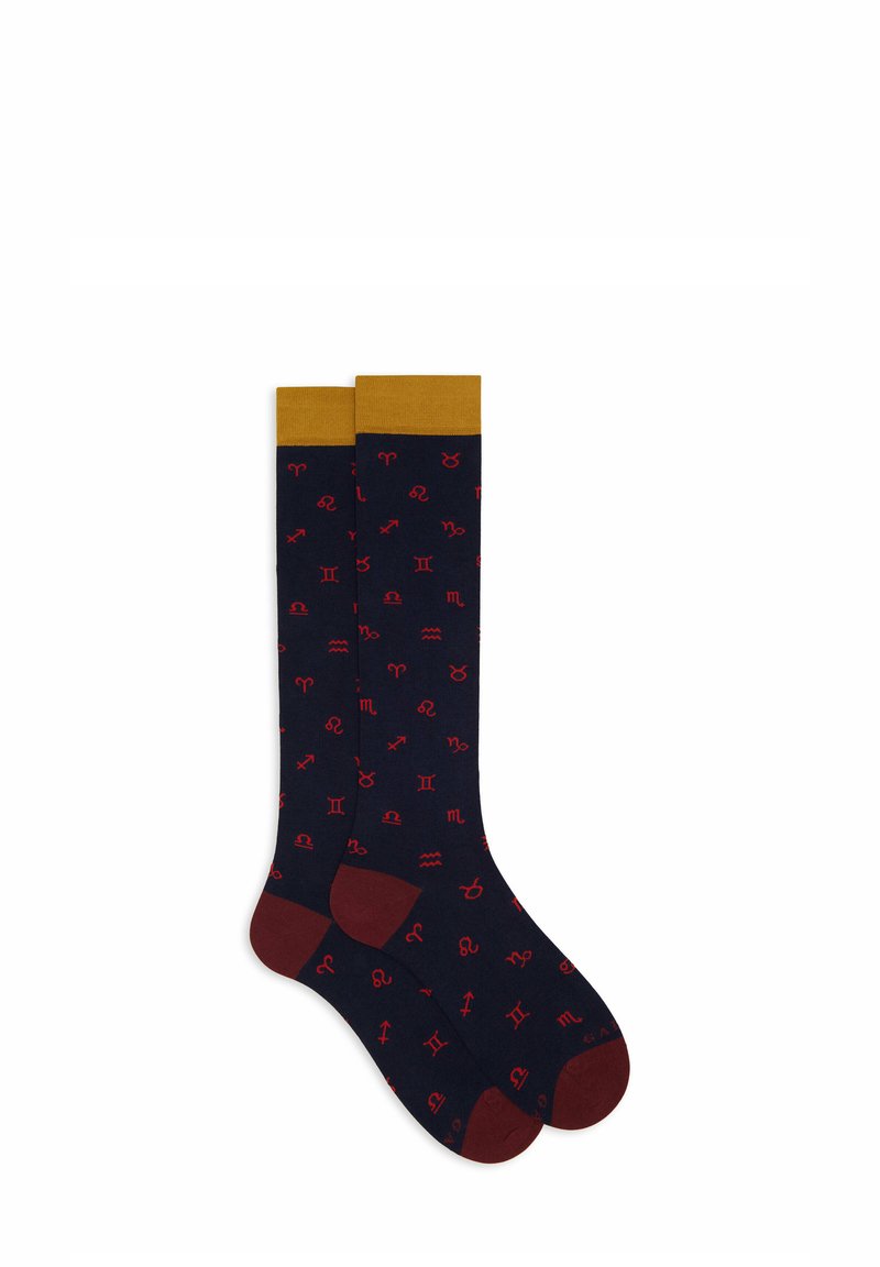 Calze blu navy con un risvolto dorato e simboli zodiacali rossi stampati in tutto. Presentano dettagli bordeaux nella zona del tallone e della punta.