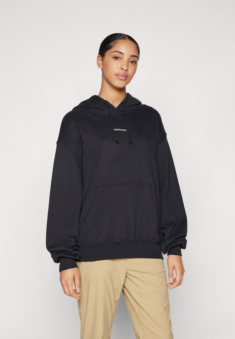 Svart hoodie med en framficka och justerbar dragsko. Har vida ärmar och en logotyp på bröstet. Mjuk tygkvalitet, lös passform.