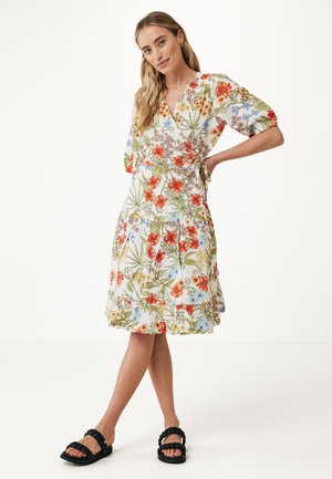 El vestido envolvente floral presenta un fondo blanco con patrones coloridos en rojo, azul y verde. Tiene mangas cortas y una falda acampanada.