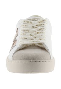 Sneakers bianche con puntale in suede beige, lati testurizzati e lacci con logo dorato in rilievo. Forma arrotondata con suola piatta e cuciture rinforzate.