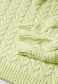 Pull en maille vert clair avec une texture en câbles, des poignets côtelés et un tissu épais et doux. Motif tressé notable sur toute la surface.