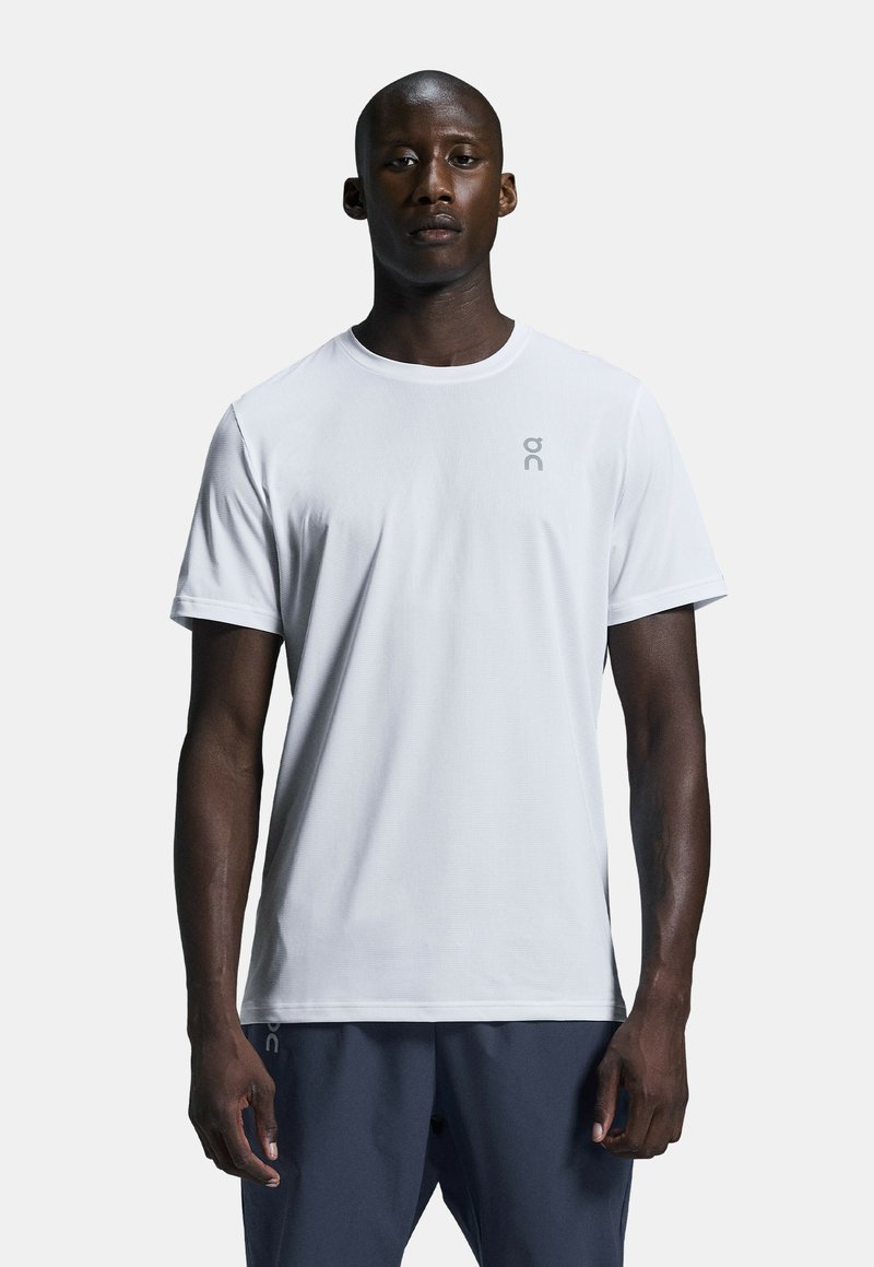 White athletic t-shirt made of lightweight fabric with a round neckline and short sleeves, featuring a subtle brand logo on the chest.