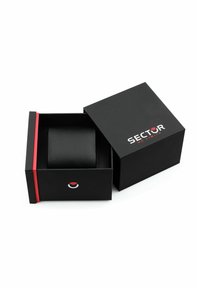 Scatola regalo in cartone nero con una banda di accento rossa, parzialmente aperta, che rivela un cuscino nero all'interno. Logo "SECTOR NO LIMITS" sul coperchio.