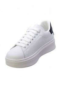 Sneakers bianchi con parte superiore in pelle liscia, punta rotonda e un accento sul tallone nero in contrasto. Presentano lacci piatti e suola piattaforma.