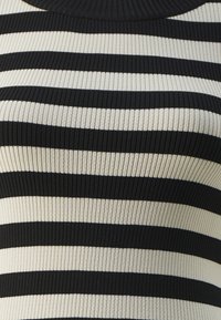 Sweter w czarno-kremowe paski, wykonany z materiału ribbed, z poziomymi paskami o różnej szerokości i okrągłym dekoltem.