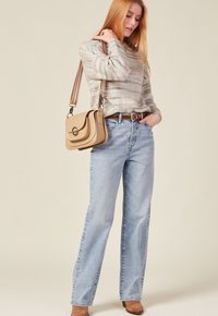 Leichtes, mehrfarbiges Strickpullover mit Streifen, kombiniert mit hochgeschnittenen hellblauen Jeans und einer beigen Umhängetasche. Braune Stiefeletten.