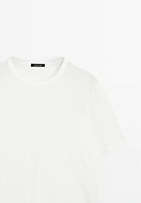 Witte crewneck t-shirt van zacht katoen, met korte mouwen en een eenvoudig ontwerp met een label bij de hals.