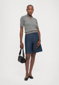 Black and white striped polo shirt, denim bermuda shorts, black handbag with textured finish, and black flats. Clean, casual look.