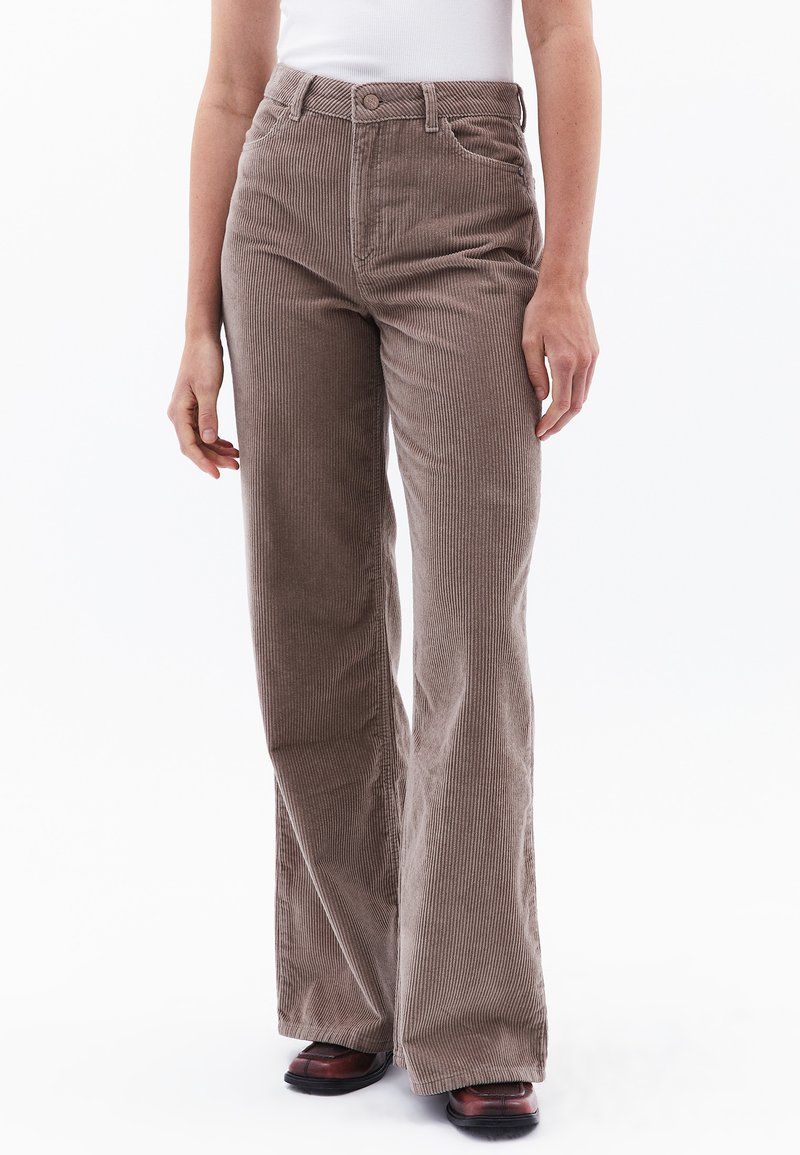 Bruine fluwelen broek met uitlopende pijpen en een geribbelde textuur, met een hoge taille, voorzakken en details met zilverkleurige knopen.