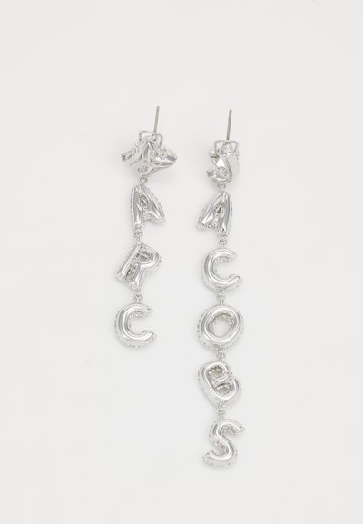 Pendientes de gota plateados que presentan letras estilizadas en tres dimensiones formando la palabra "ARCOBAS", con un acabado brillante y un diseño colgante.