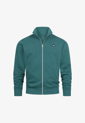Blågrön zip-up sweatshirt med hög krage, ribbade muddar och en liten logotyp på vänstra bröstet. Mjuk tygstruktur och minimalistisk design.