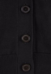 Sort strikket stof med tre store sorte firehuls-knapper i en lodret række og ribkant nederst.