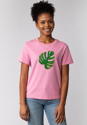 T-shirt en coton rose avec un imprimé de feuille de monstera verte. Manches courtes et col rond, avec une texture douce.