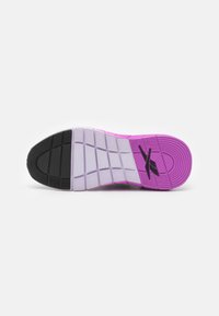 Suela de zapato con una banda de rodadura segmentada en negro, blanco y rosa, que presenta un logo estilizado negro en la sección del talón rosa sobre un fondo blanco.
