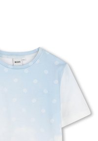 Lichtblauw katoenen T-shirt met een herhaald logo-patroon, korte mouwen, ronde hals en een soepele textuur. Witte accenten op de mouwen.