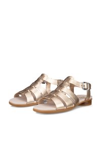 Pár fémes arany színű lapos szandál több pánttal és oldalsó csattal, fehér háttéren.