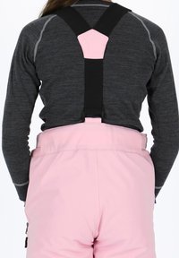 Ski hängslen med justerbara svarta remmar och en rosa bakpanel. Tillverkade av slitstark tyg, med en mjuk yta och funktionell design.
