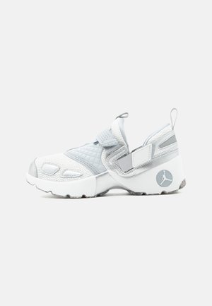 Άσπρο και γκρι αθλητικό παπούτσι slip-on με δίχτυ, καπιτονέ ύφασμα, ρυθμιζόμενα λουράκια και κυκλικό λογότυπο στη φτέρνα.