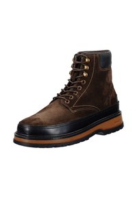 Hnědé semišové boty na šněrování s černou koženou špičkou a silnou hnědou gumovou podrážkou. Disponují zlatými detaily a kontrastním prošíváním.