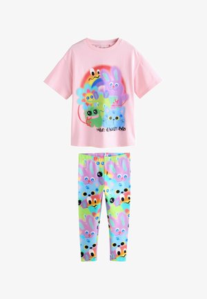 Roza bombažna majica s večbarvnimi grafičnimi motivi živali in napisom, v kombinaciji z legicami z živahnimi pastelnimi vzorci obrazov zajcev.